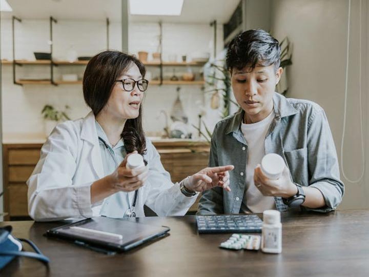 A doctor speaking with a patient about the hormone replacement therapy treatment they are prescribed. 