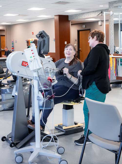 A woman doing physical therapy on a machine in Le Mars, IA