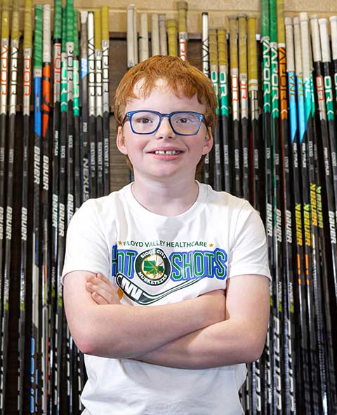 A young pediatric patient wearing glasses, smiling for a photo in Le Mars, IA