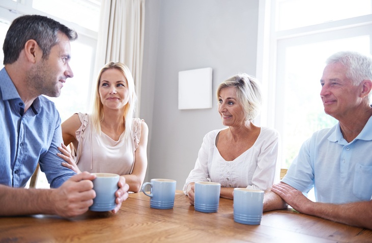 Shot of a young couple talking with their parents about healthcare decisions.