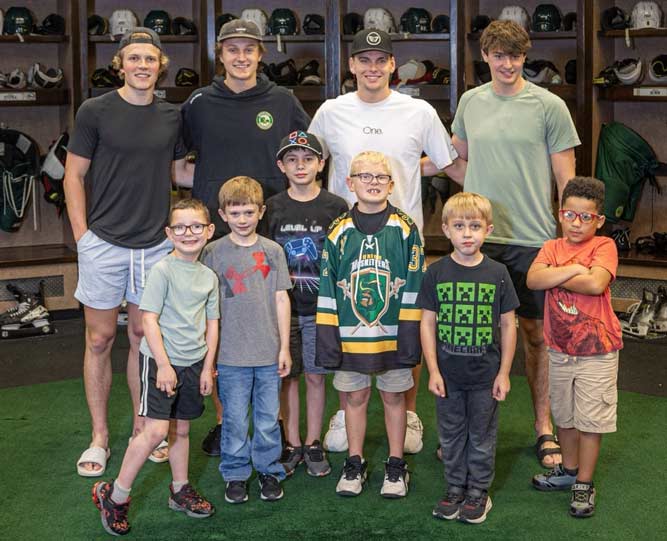 A group of young boys & men smiling together for a photo in Sioux City, IA