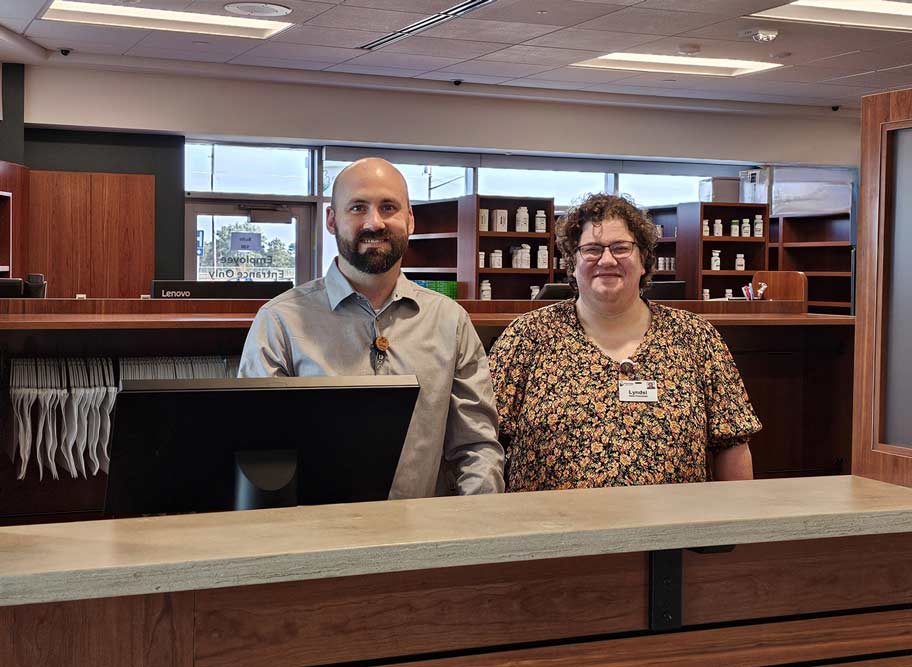 A man and woman stand behind pharmacy counter in Le Mars, IA